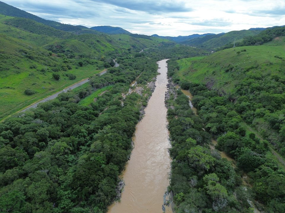 Rio com margens de mata ciliar e pastagens verdes no período chuvoso