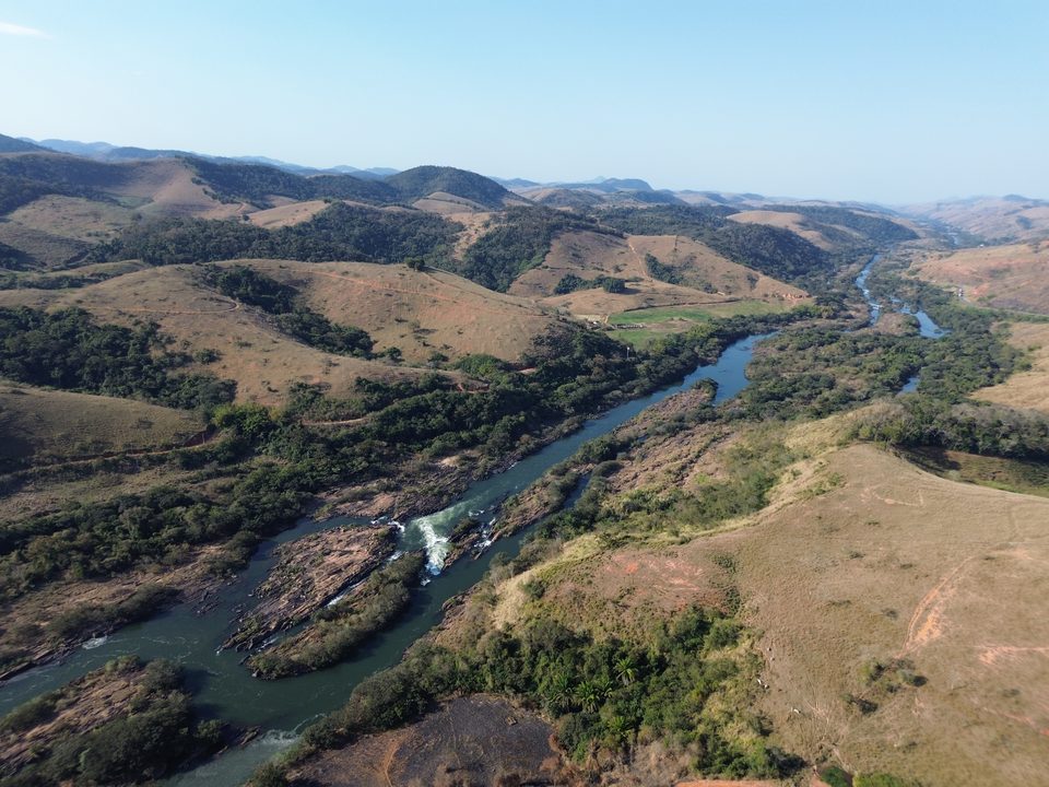 Trecho de corredeiras do rio entre morros, visto do alto
